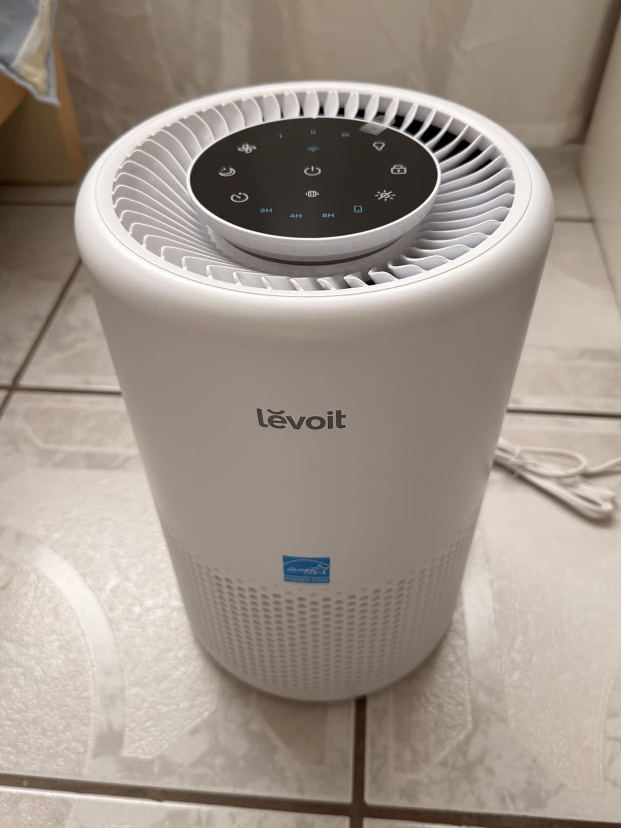 White Levoit air purifier with touch controls in a home